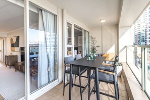 Un appartement moderne doté d’un balcon, d’un coin repas et d’un salon avec un canapé et une table basse.