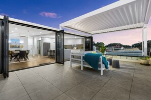 Un espacio habitable moderno y de concepto abierto con comedor, cocina y un balcón con vistas.