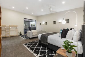 A modern bedroom with a bed, bedside table, and a large window.