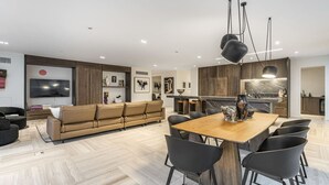 A modern living room with a sofa, dining table, and chairs.