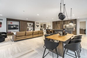 Un salon moderne avec un canapé, une table à manger et des chaises.