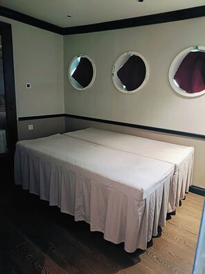A room with a large bed, three wall-mounted mirrors, and a wooden floor. - Verdure Lotus Classic Cruise on Lan Ha Bay (Tuan Chau)
