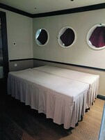 Una habitación con una cama grande, tres espejos en la pared y suelo de madera.