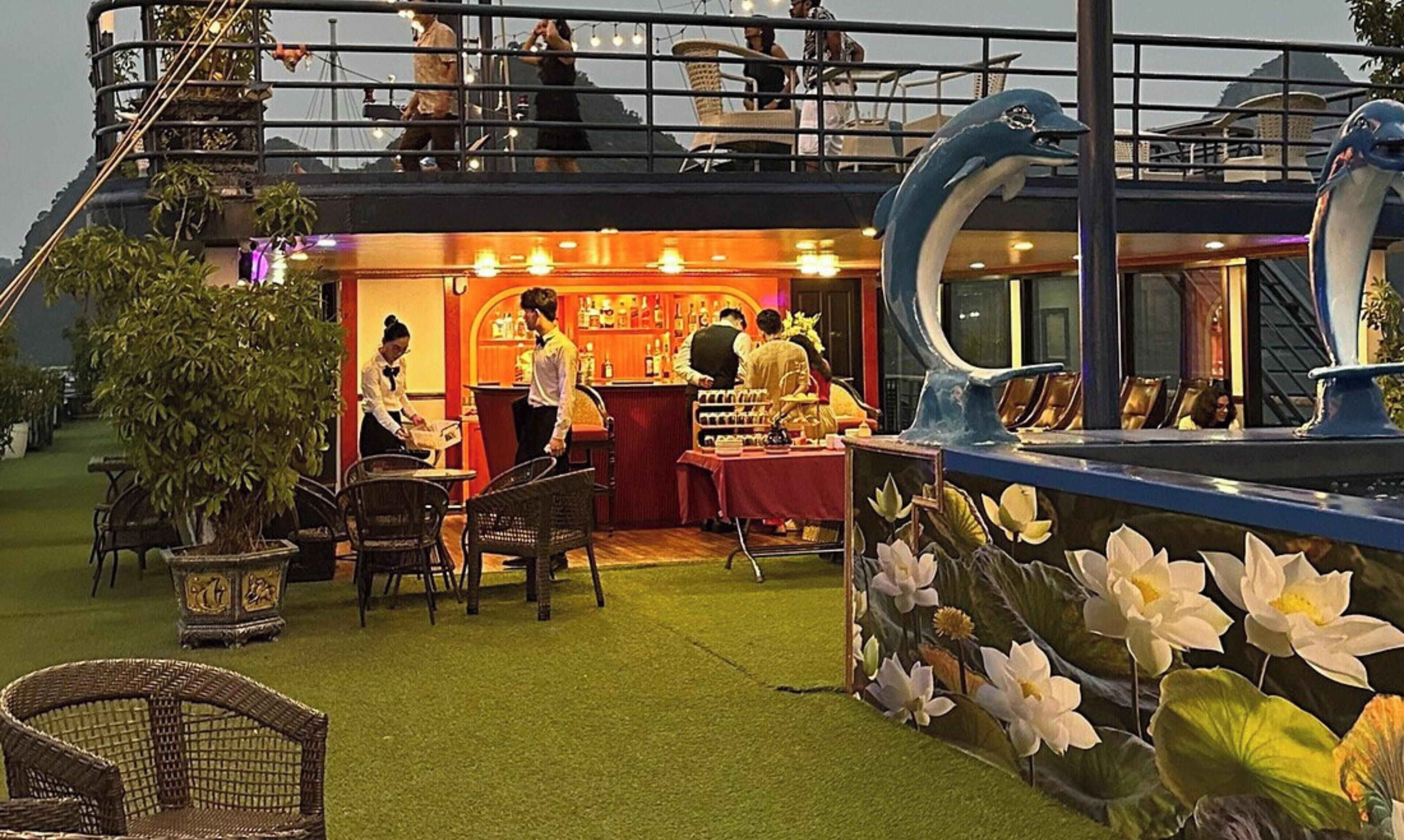 A restaurant with outdoor seating, a bar, and a decorative dolphin sculpture.