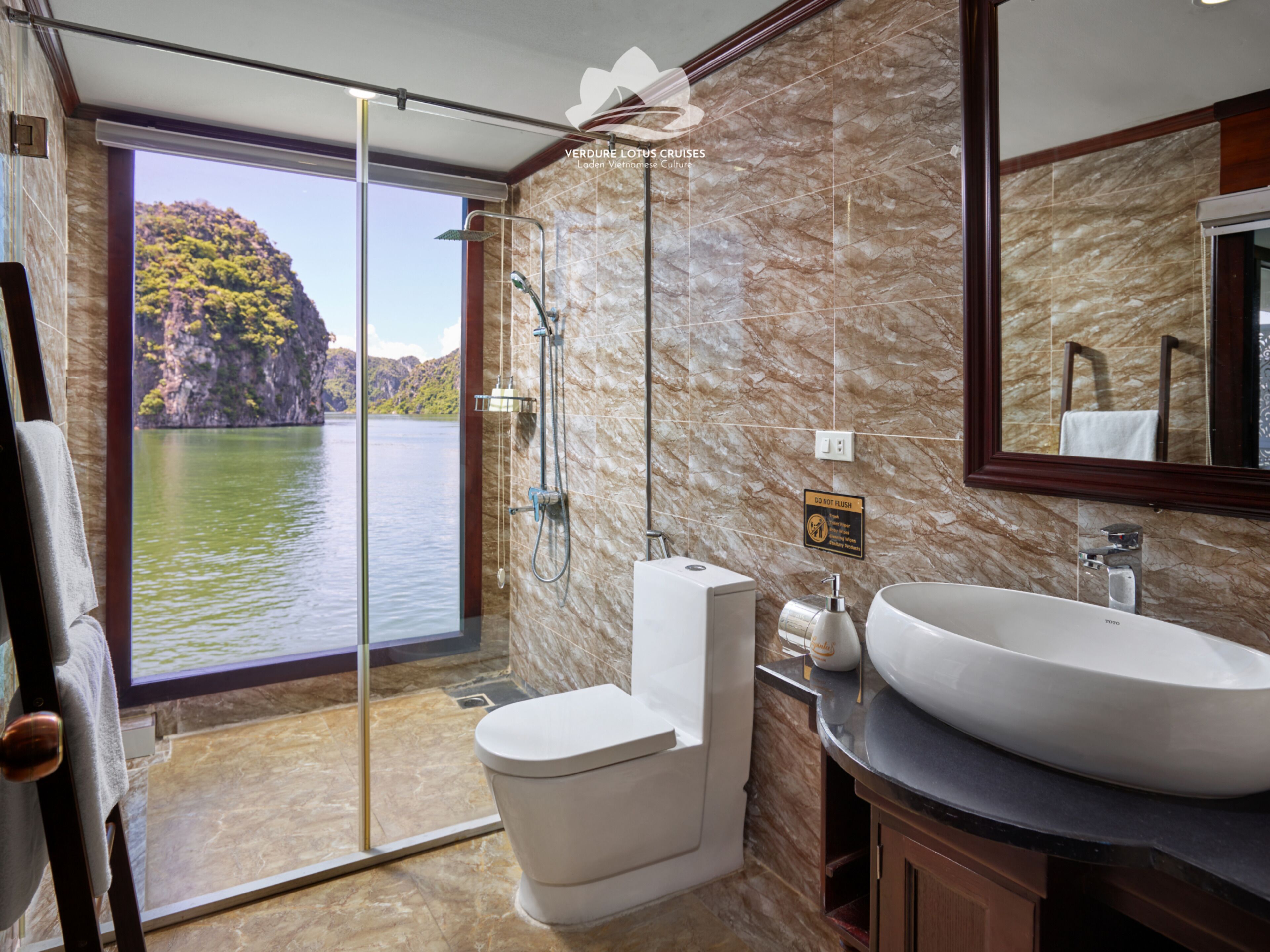 A bathroom with a large window, a toilet, a sink, and a shower.