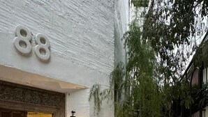 A building with the number 88, a closed sign, and a small outdoor seating area with wicker furniture. - Cataleya Estate Boutique Hotel (Bangkok)