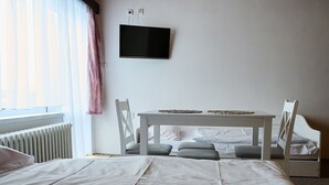 A bedroom with a bed, a table, and two chairs. - Vacation home Burger by Interhome (Harrachov)