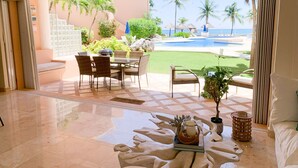 Una habitación amplia con vista a una piscina y palmeras.
