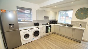 Una cocina moderna con lavadora integrada, microondas y refrigerador.