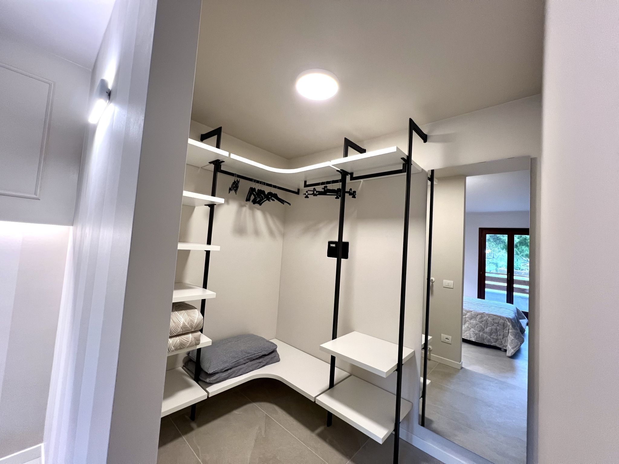 Ein moderner, gut beleuchteter Raum mit eingebautem Sitzplatz, Regalen und einer Klimmzugstange.