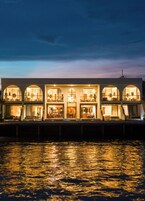 Un hotel frente al agua con varios balcones y amplias ventanas, que ofrece vistas al agua.