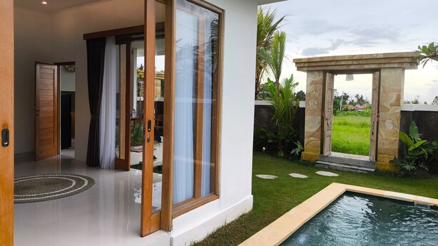 Ein modernes Haus mit Glastür und anschließendem Patio.