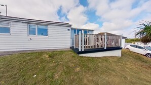 A single-story mobile home with a fenced porch and a small deck. - G23 Norda, Riviere Towans (Hayle)
