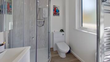 Ein Badezimmer mit Duschkabine, Toilette und Waschbecken.