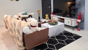 Un salon moderne avec un canapé, une table basse, un téléviseur et une cheminée.
