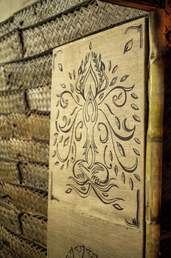 Primer plano de una pared texturizada con un panel decorativo que presenta diseños intrincados.