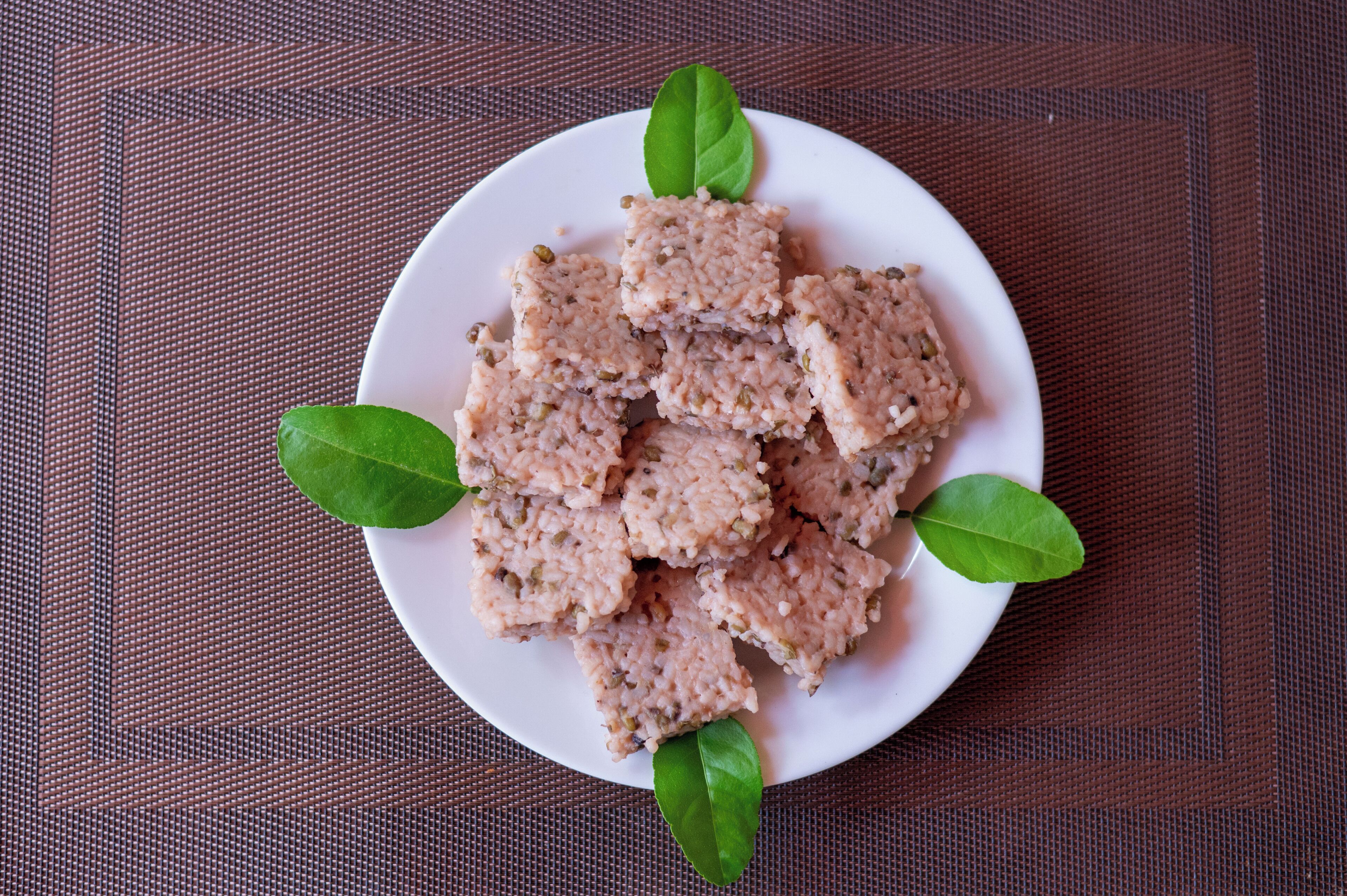 A plate of food with green leaves on a textured surface.