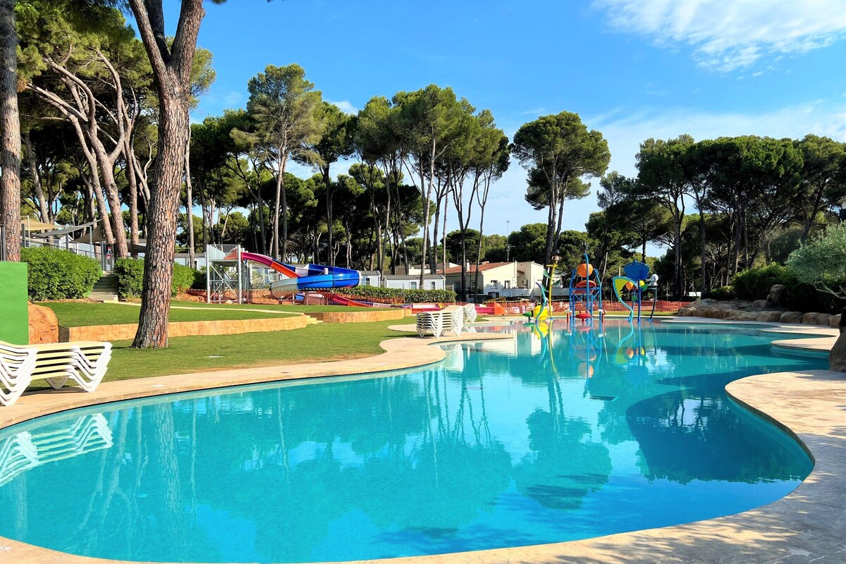 A swimming pool with a water slide and a children's play area.