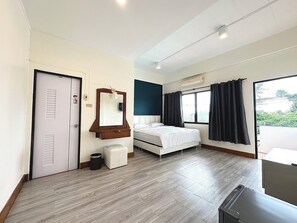 Una habitación de hotel con cama, espejo, ventana con cortinas, puerta y un cesto de basura.