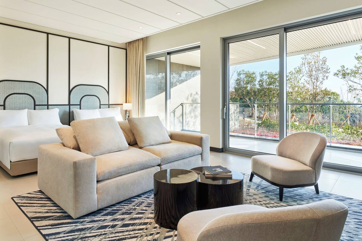 Une chambre d’hôtel moderne avec un canapé, un fauteuil et un lit.