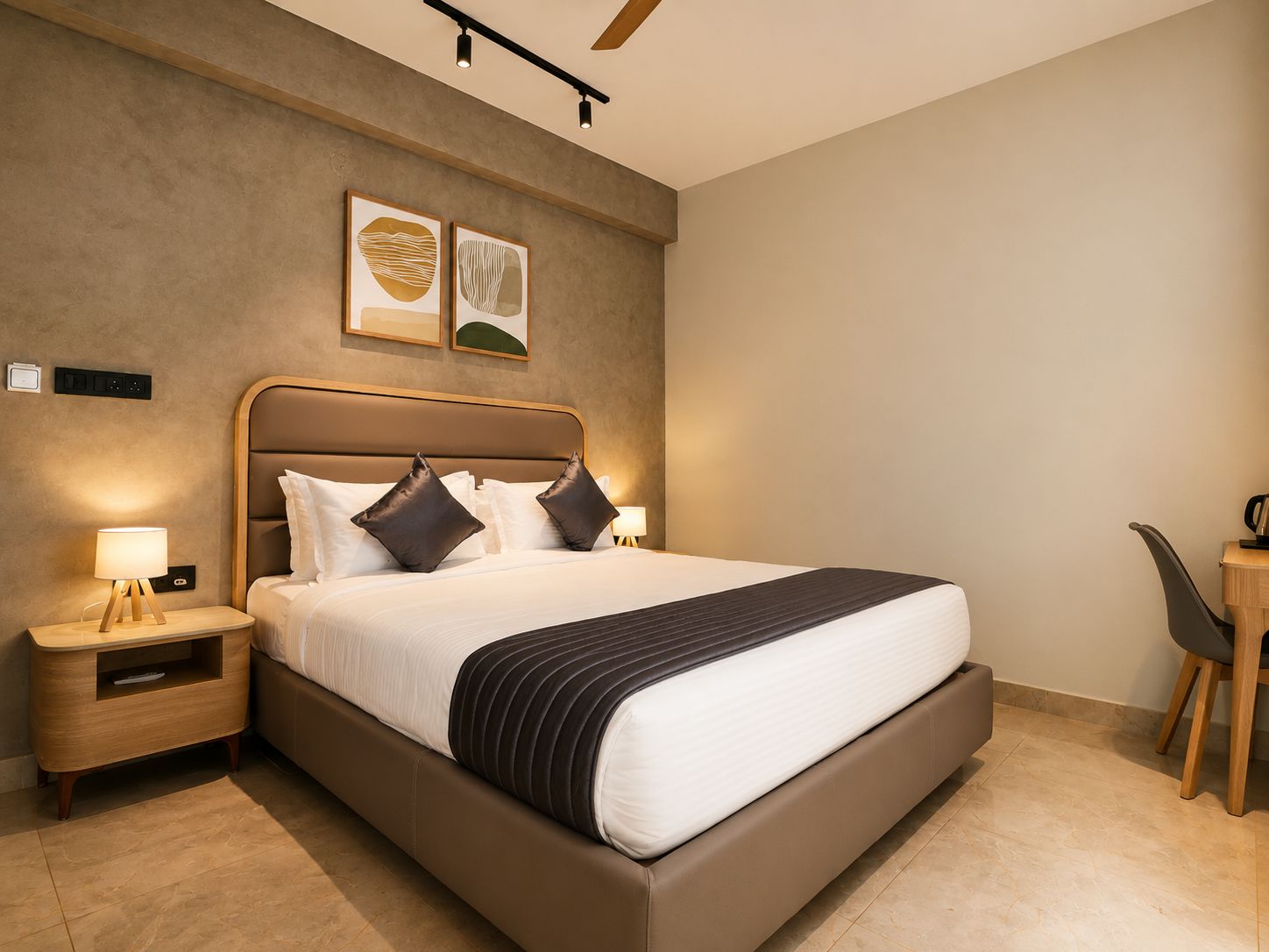 Une chambre d’hôtel moderne avec un grand lit, des tables de chevet, un bureau et une chaise.