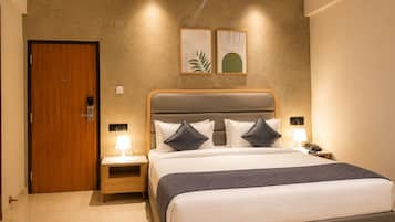 Een hotelkamer met een bed, nachtkastjes, een houten deur en kunst aan de muur.