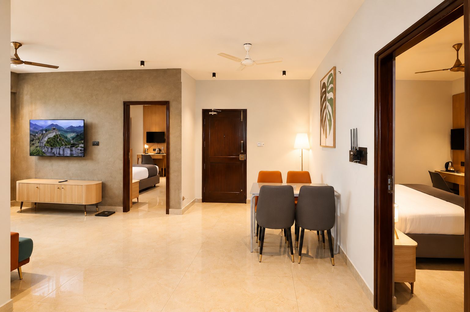 Una habitación de hotel con una cama, un escritorio, un televisor y una zona de comedor con sillas.