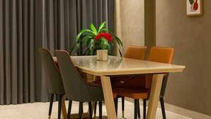 A dining area with a table, chairs, a ceiling fan, and a window with curtains. - Dlite Rivera  (Bengaluru)