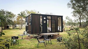 Una casa moderna e compatta con una terrazza, posti a sedere all'aperto e un'area cucina a vista.