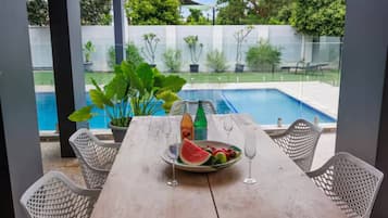 Enjoy a romantic meal for two in this serene outdoor dining area overlooking the pool and lush garden.
