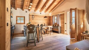A cozy wooden interior with a dining area, kitchen, and a large window.