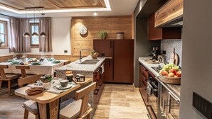 Une cuisine moderne avec des meubles en bois, un îlot central et un coin repas comprenant une table et des chaises en bois.