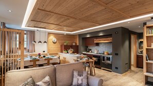 Une cuisine moderne avec des meubles en bois, un îlot central et un coin repas comprenant un canapé et une table.