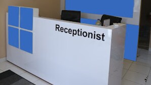 A reception desk labeled "Receptionist" with a blue accent panel. - Collection O metroploitian park Serviced Apartmen (Bekasi)