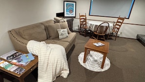 Ein gemütliches Wohnzimmer mit einer Couch, einem Couchtisch und einem Fernseher.
