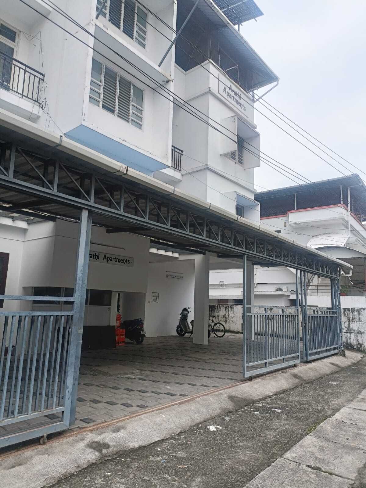 Un immeuble à plusieurs étages doté d’une entrée couverte et d’une enseigne indiquant « Appartements ».