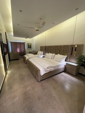 A modern bedroom with a large bed, a sofa, and a desk. - Loft BnB F10 Guest House (Islamabad)