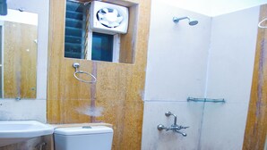 A bathroom with a toilet, sink, and shower. - VS Cube Estancia (Yercaud)