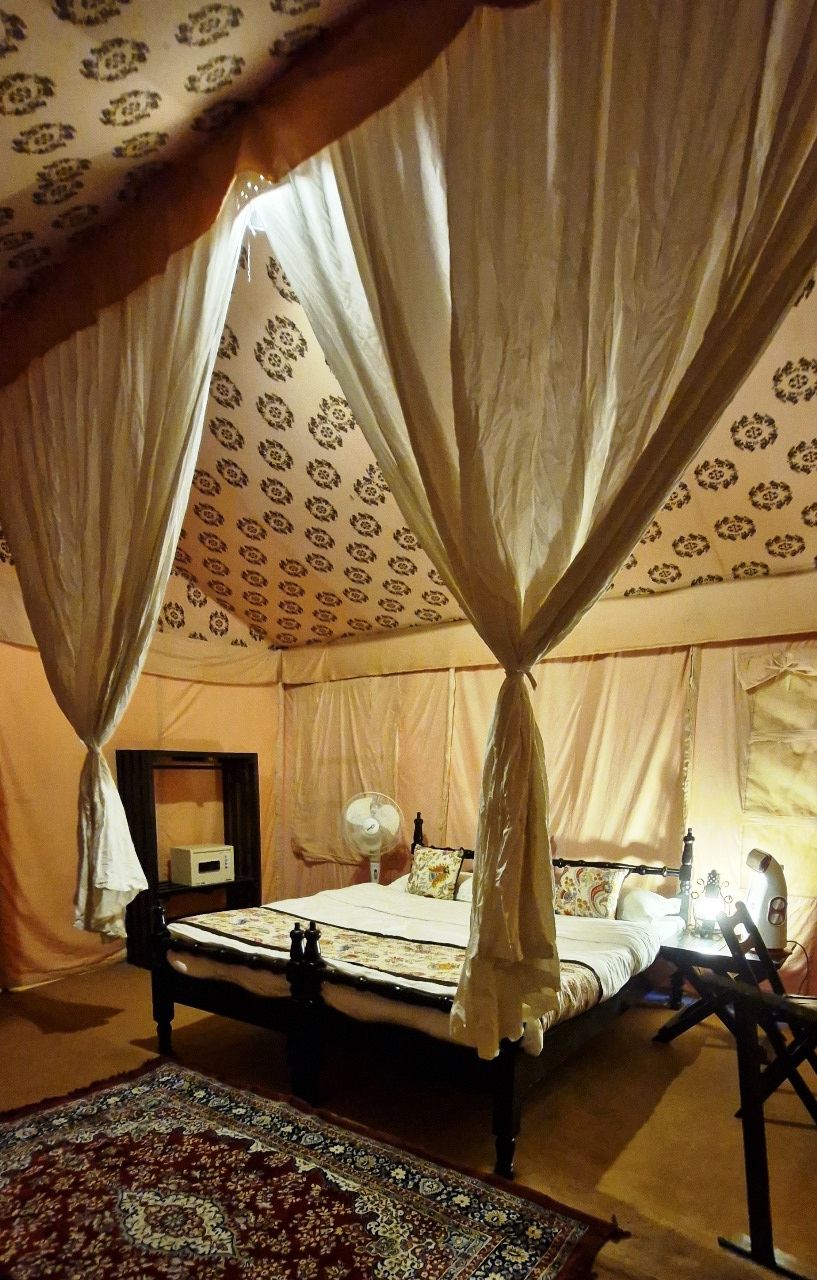 Une chambre avec un lit, une table de chevet, une lampe et une chaise.