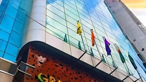 Un edificio moderno con fachada de vidrio y un letrero que dice 'GRAND PALACE'.