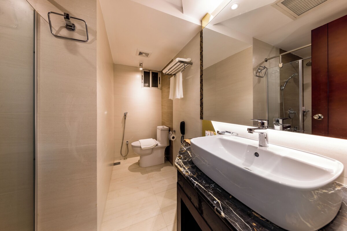 A modern bathroom with a large sink, a toilet, and a shower area.