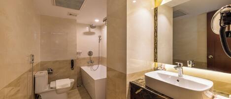 Une salle de bain moderne avec une baignoire, des toilettes, un lavabo et un grand miroir.