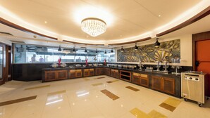 Una cocina amplia con una isla central, una araña y un diseño moderno.