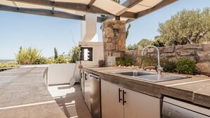 An outdoor kitchen with a stone wall, a sink, and a dishwasher. - Villa Kera Panorama - villa with pool, Crete (Vámos)