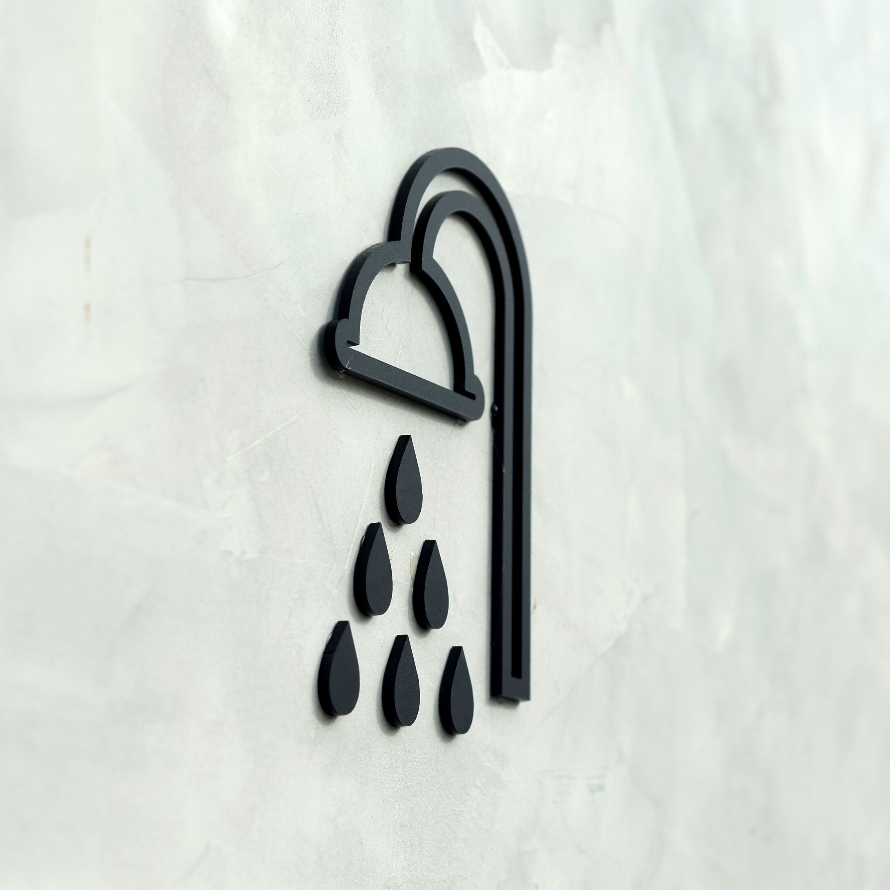 A stylized icon of a shower with a curved spout and water droplets.