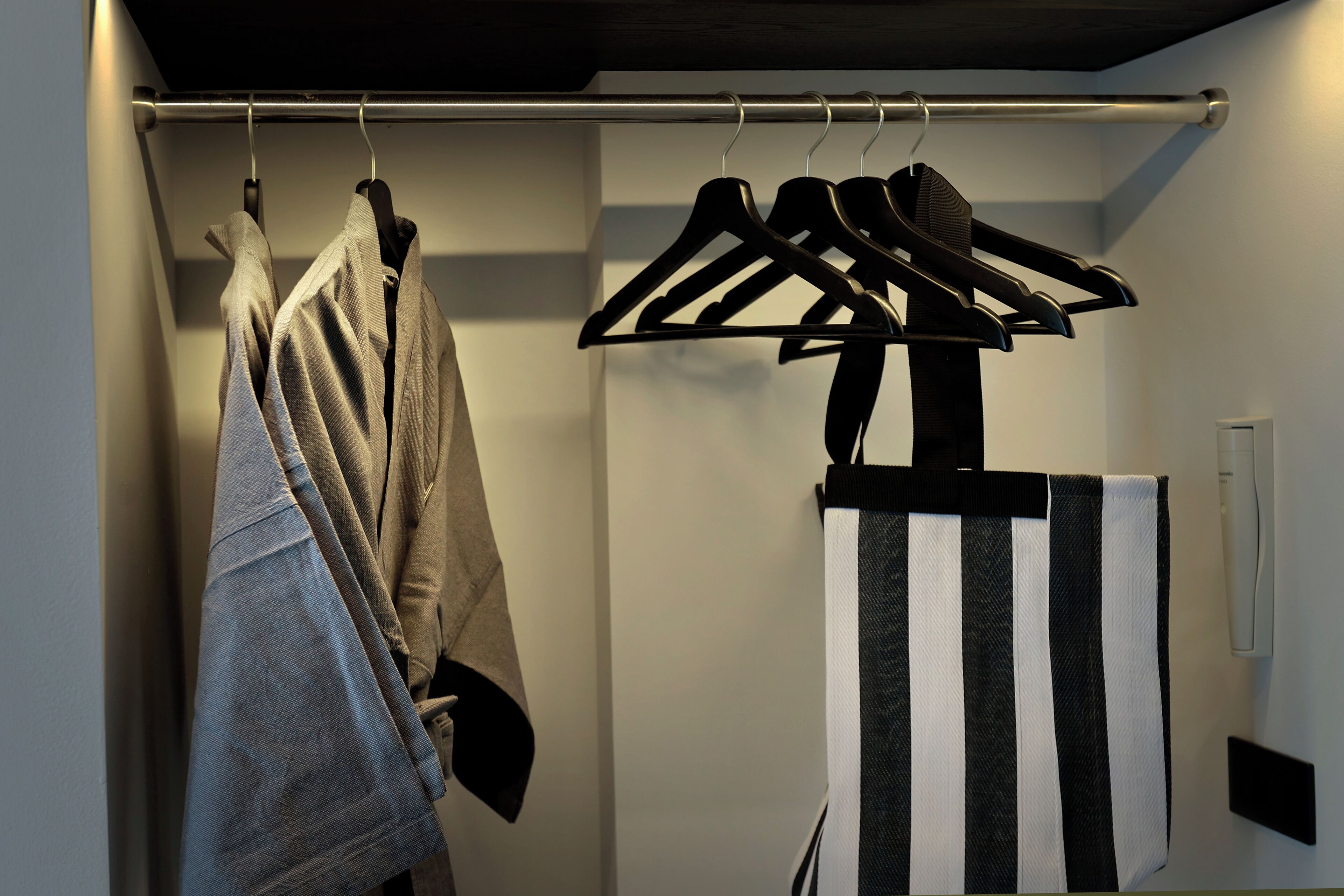 Een kast met kleding en een handdoekhouder.