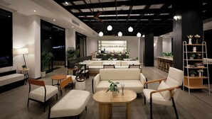 Ein stilvoller Lounge-Bereich mit Sofas, Tischen und einer Bar.