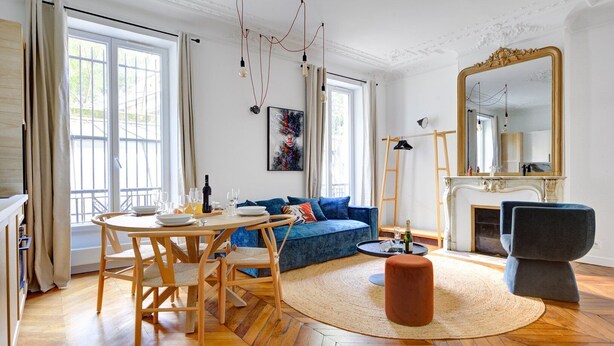 Ein modernes Wohnzimmer mit Holzesstisch, blauem Sofa und Kamin.