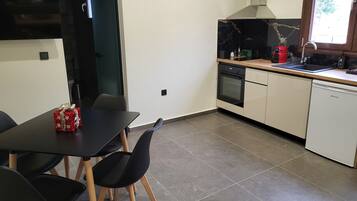 A modern kitchen with a black countertop, white cabinets, and a built-in oven.