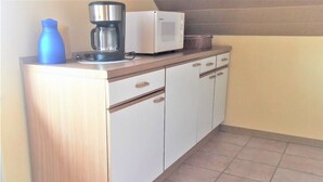 A kitchenette with a coffee maker, microwave, and cabinets. - Apartment 'Sonnenblick - Fewo 1' with Balcony and Wi-Fi (Fischbach bei Dahn)